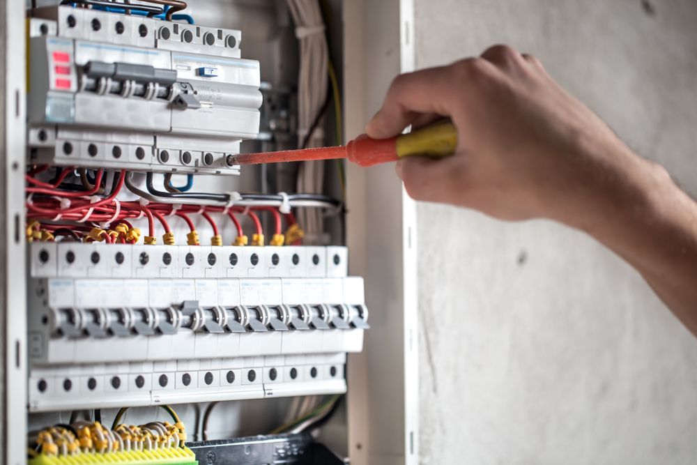A Person Is Working On An Electrical Box With A Screwdriver — Firewerx In Parkes, NSW