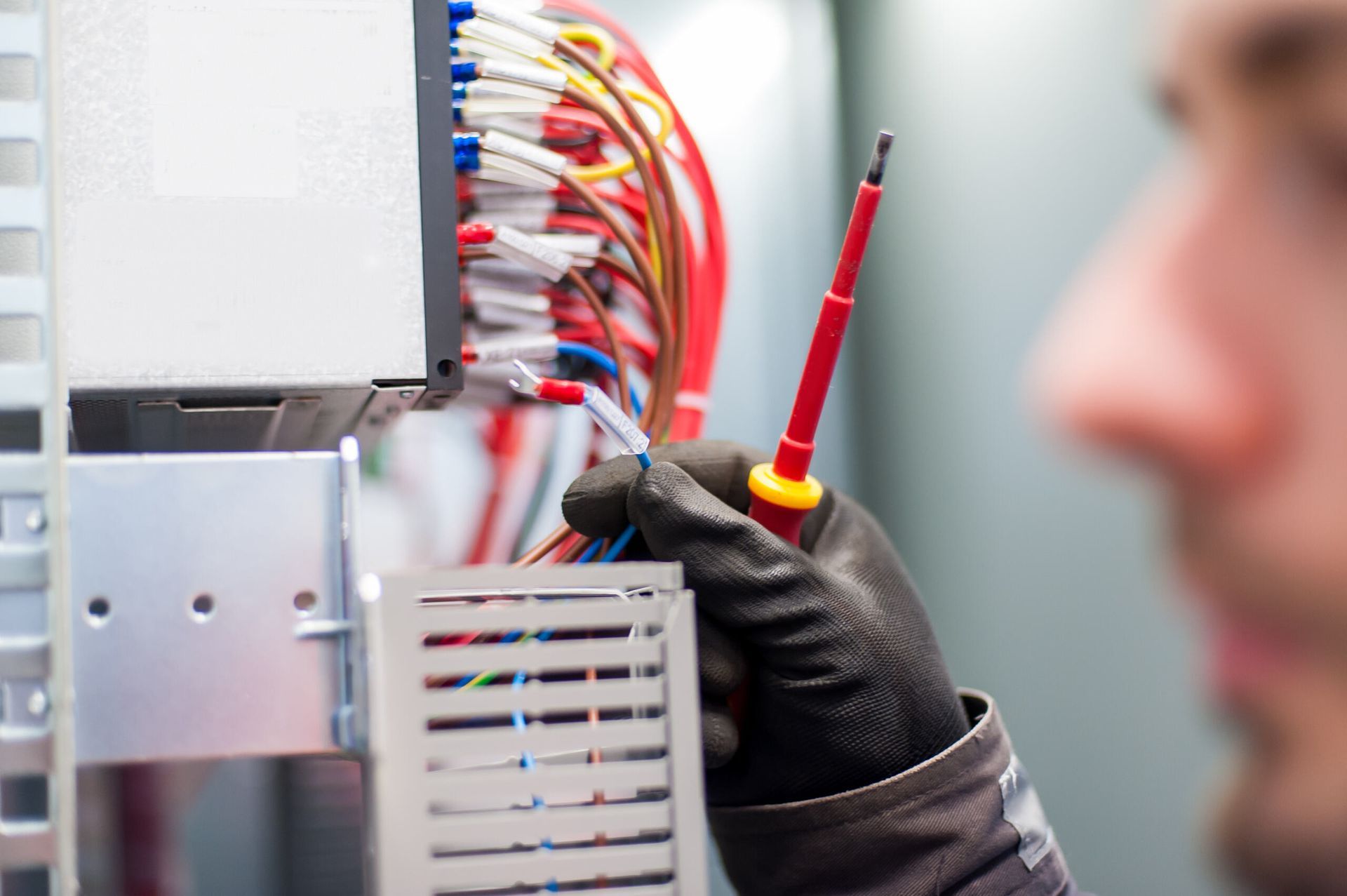 A Man Is Holding A Screwdriver In Front Of A Bunch Of Wires — Firewerx In Dubbo, NSW