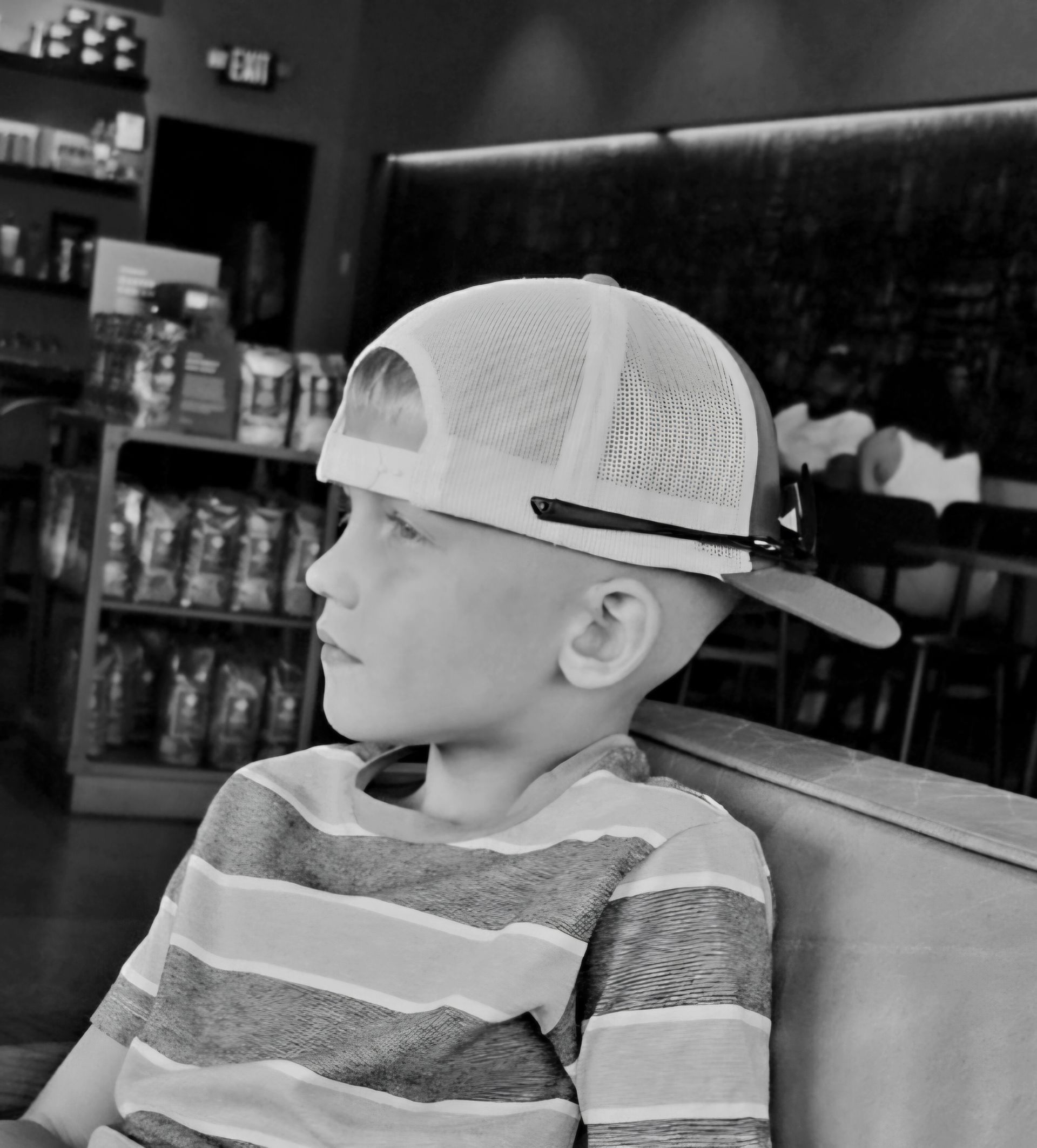A young boy wearing a hat is sitting on a couch