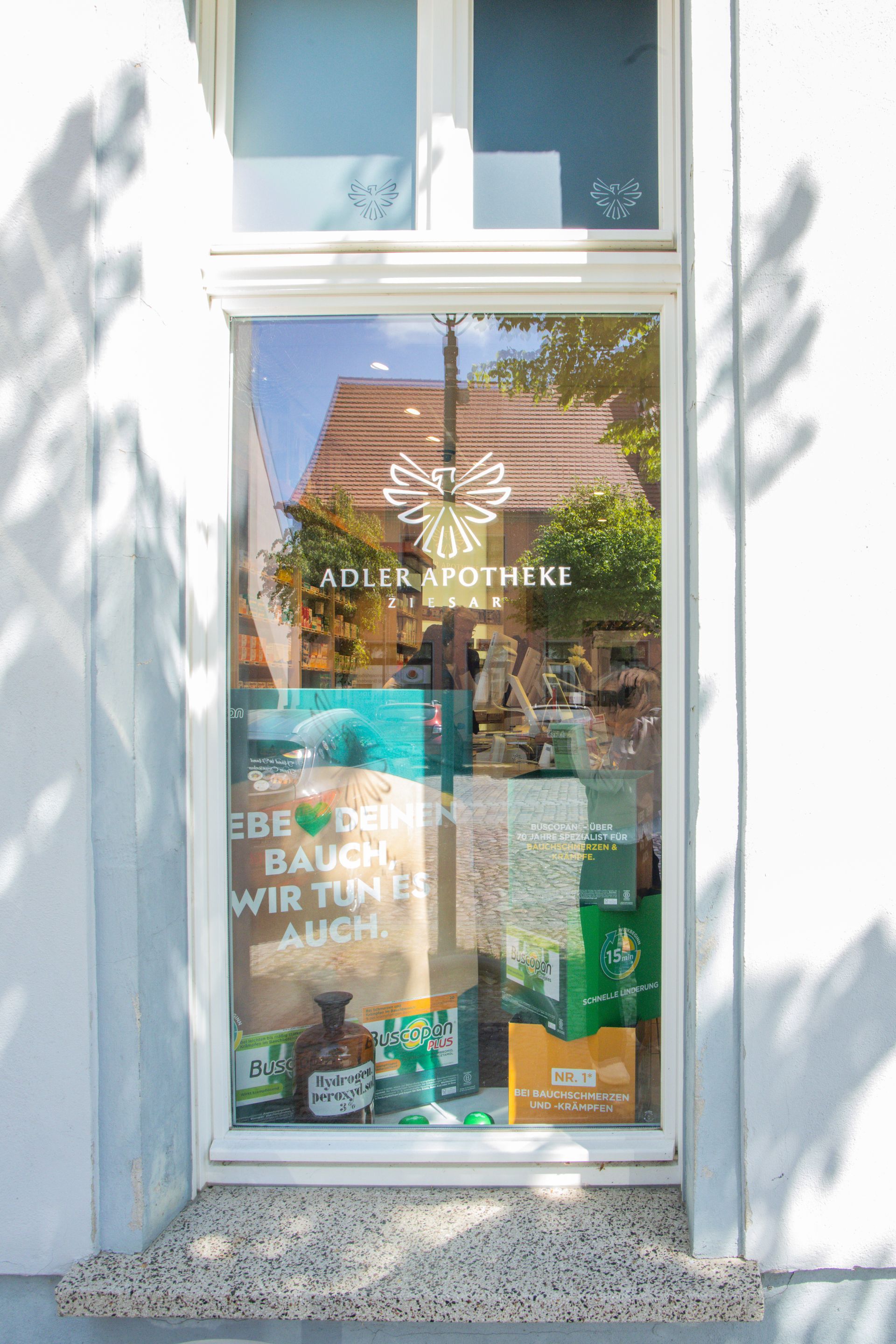 Ein Fenster einer Apotheke mit einer Produktauslage darin.
