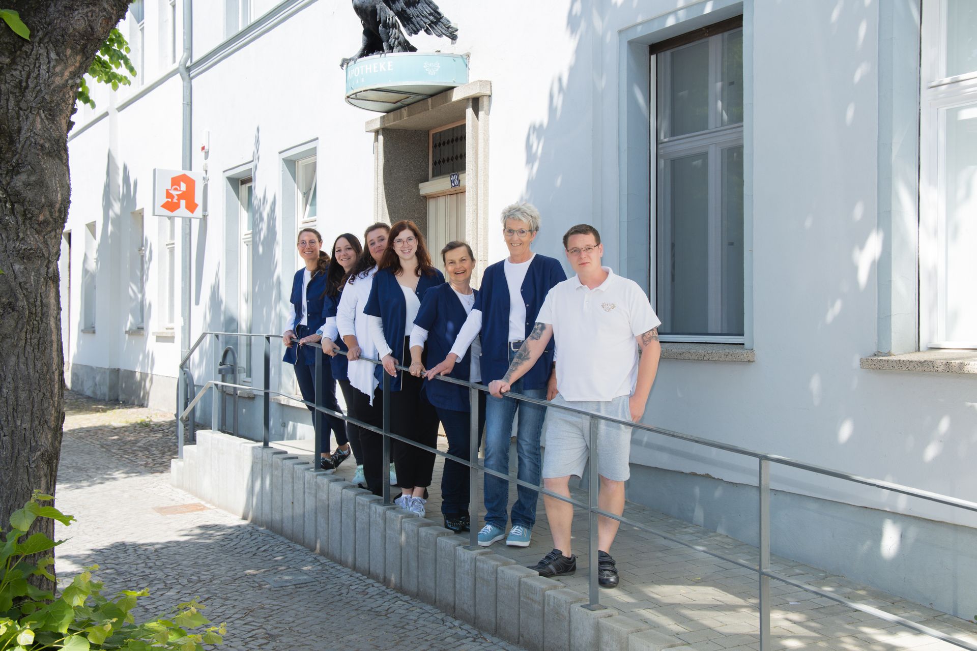 Eine Gruppe von Menschen steht auf einer Rampe vor einem Gebäude.