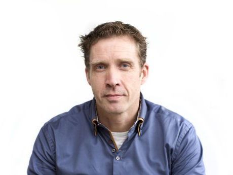 Man in a blue shirt looking at the camera against a plain white background