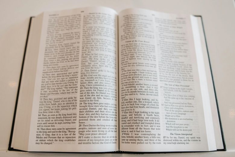 Open book with two dense columns of small black text on white pages