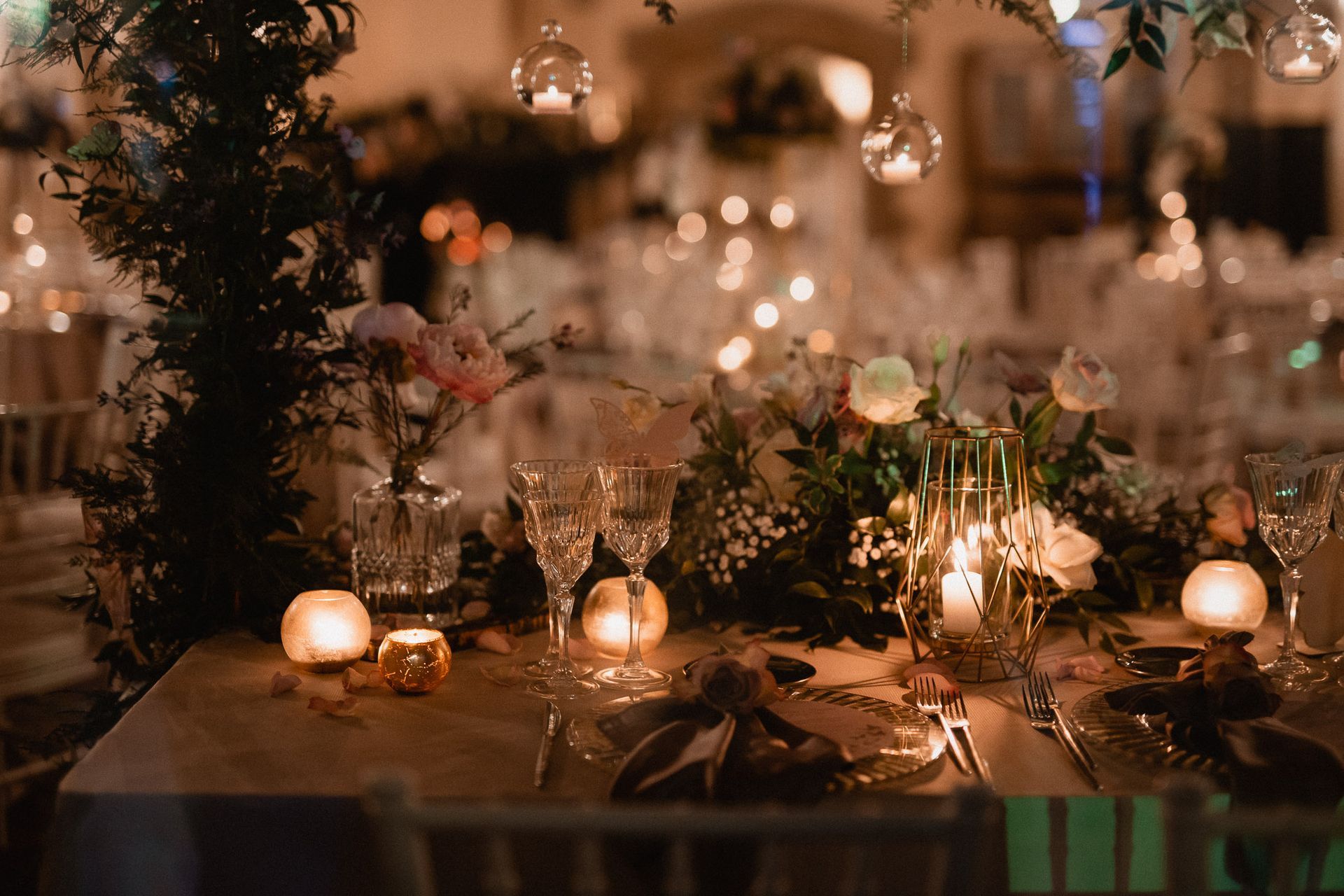Elegante tavolo per il ricevimento di nozze con candele, fiori e calici da champagne.