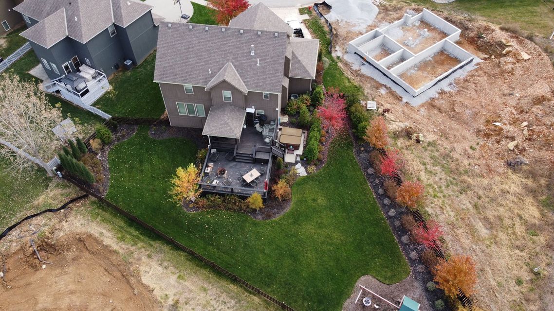 An aerial view of a house with a large lawn and a patio.