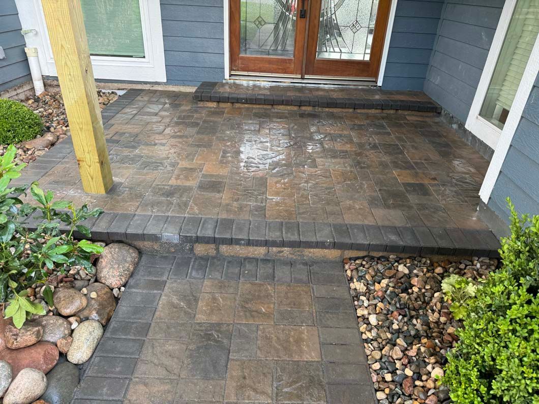 A brick walkway leading to the front door of a house.