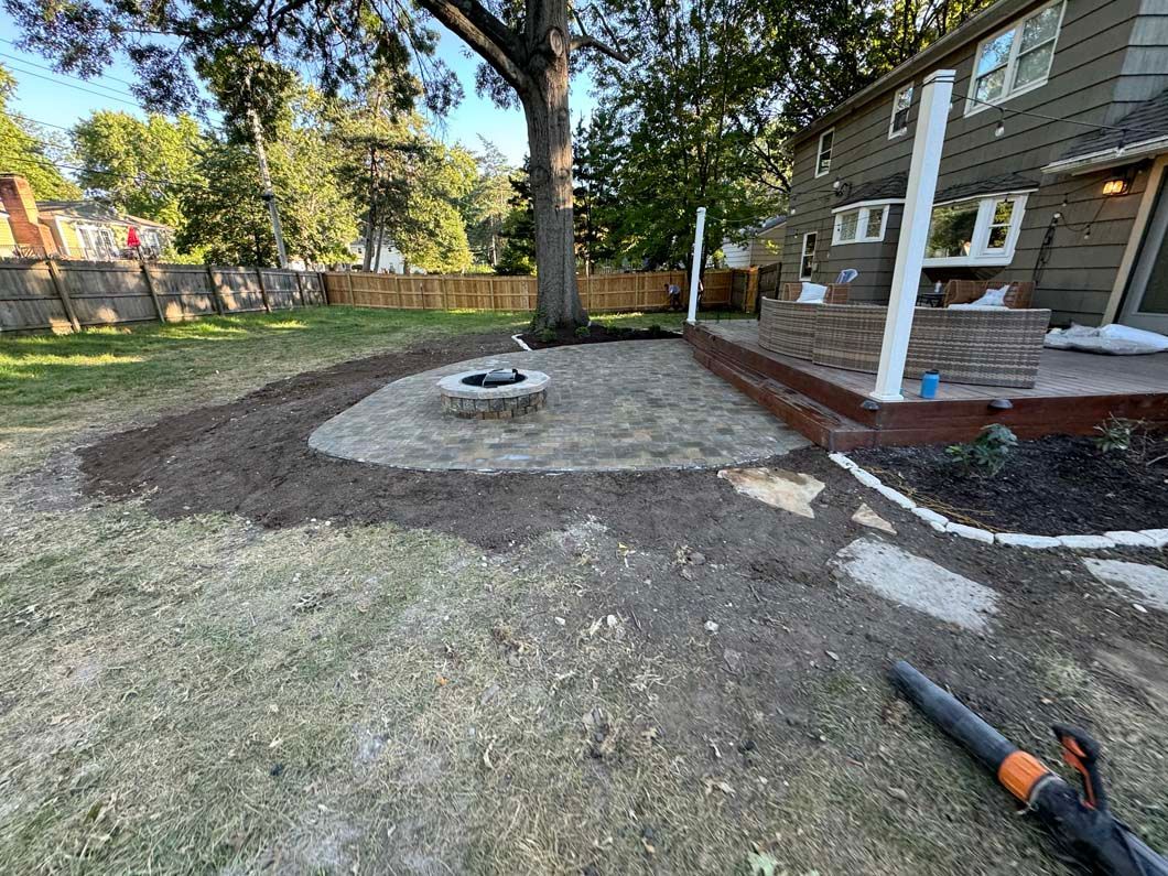A fire pit is being built in the backyard of a house.