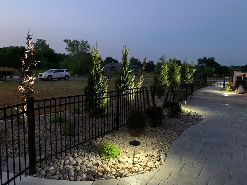 A fence with lights on it and trees in the background