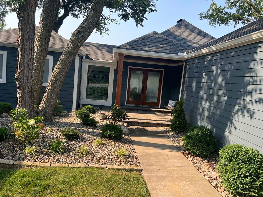 A blue house with a walkway leading to the front door.