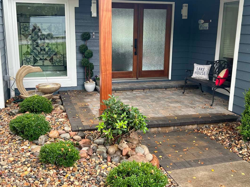 A blue house with a patio and a wooden pergola in front of it.