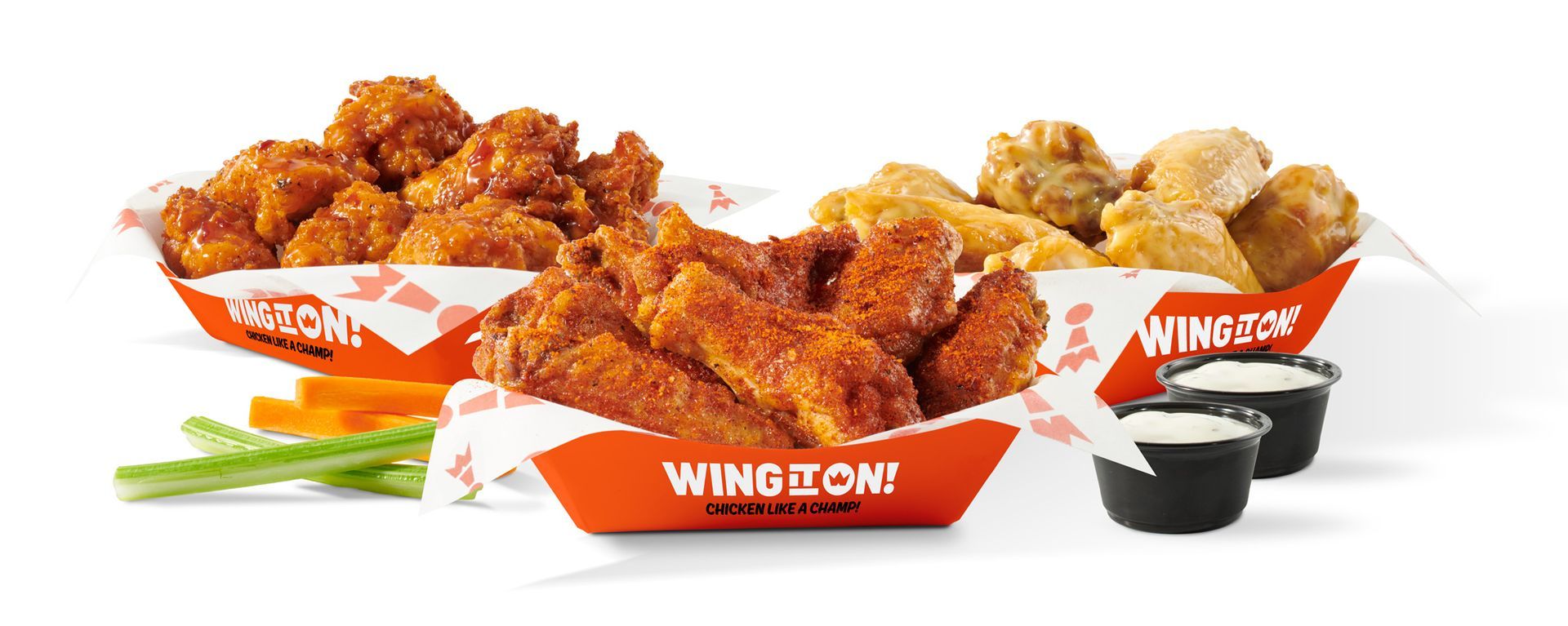 Orange-glazed chicken wings in Wing It On! baskets with celery and dipping sauce on a white background
