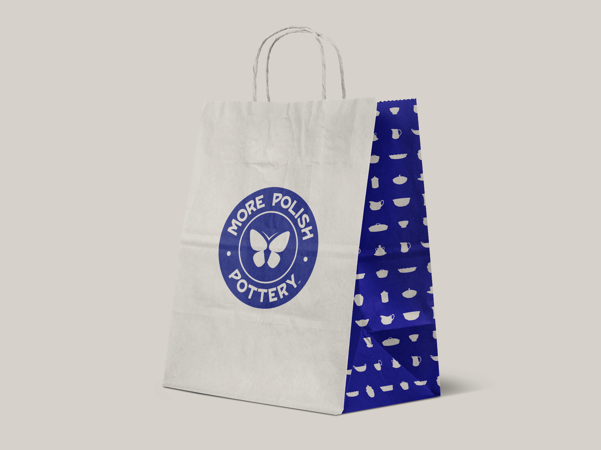 White tote bag with blue “More Polish Pottery” logo and patterned blue side panel on a light background