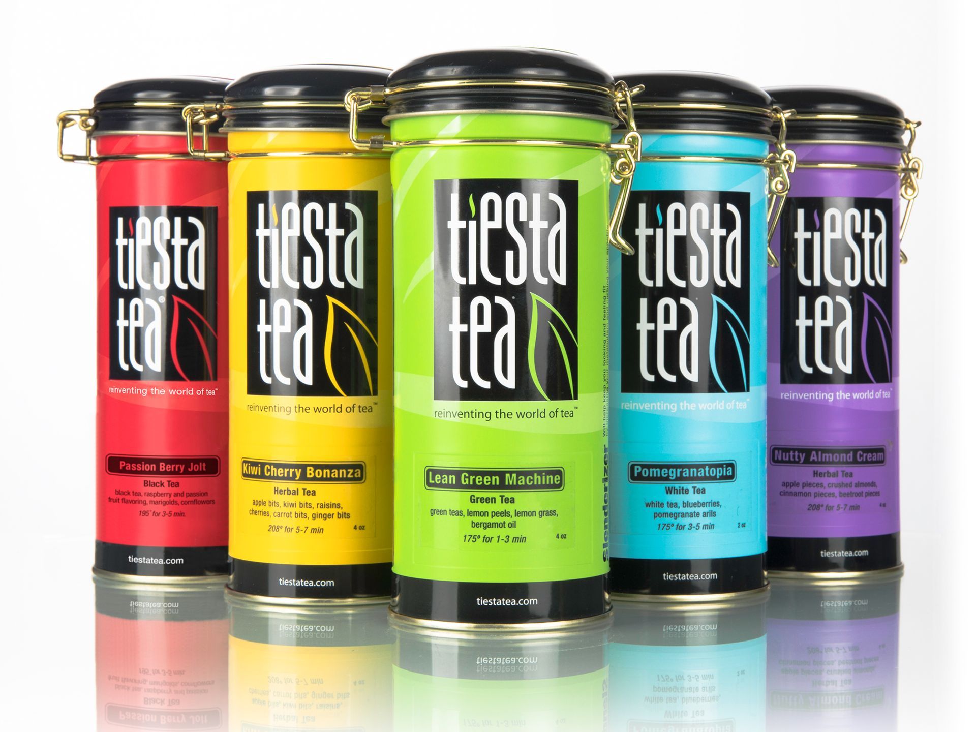 Five colorful Tiesta tea cans in red, yellow, green, teal, and purple on a white background