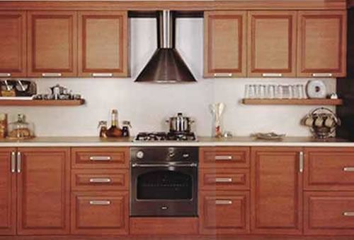 A kitchen with wooden cabinets and a stove top oven Wooden kitchen cabinets with a stainless steel range hood, stove, and oven.