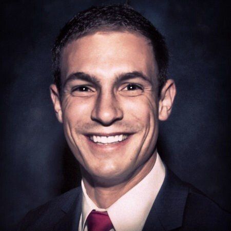 A man in a suit and tie smiles for the camera