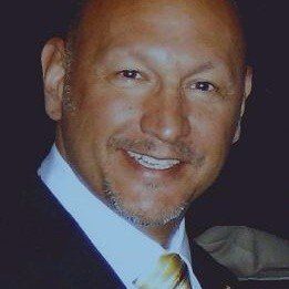 A man in a suit and tie is smiling for the camera.
