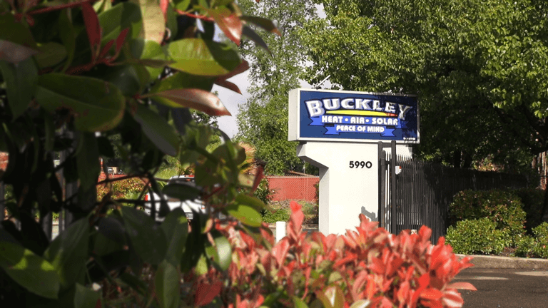 A buckley sign is surrounded by trees and bushes