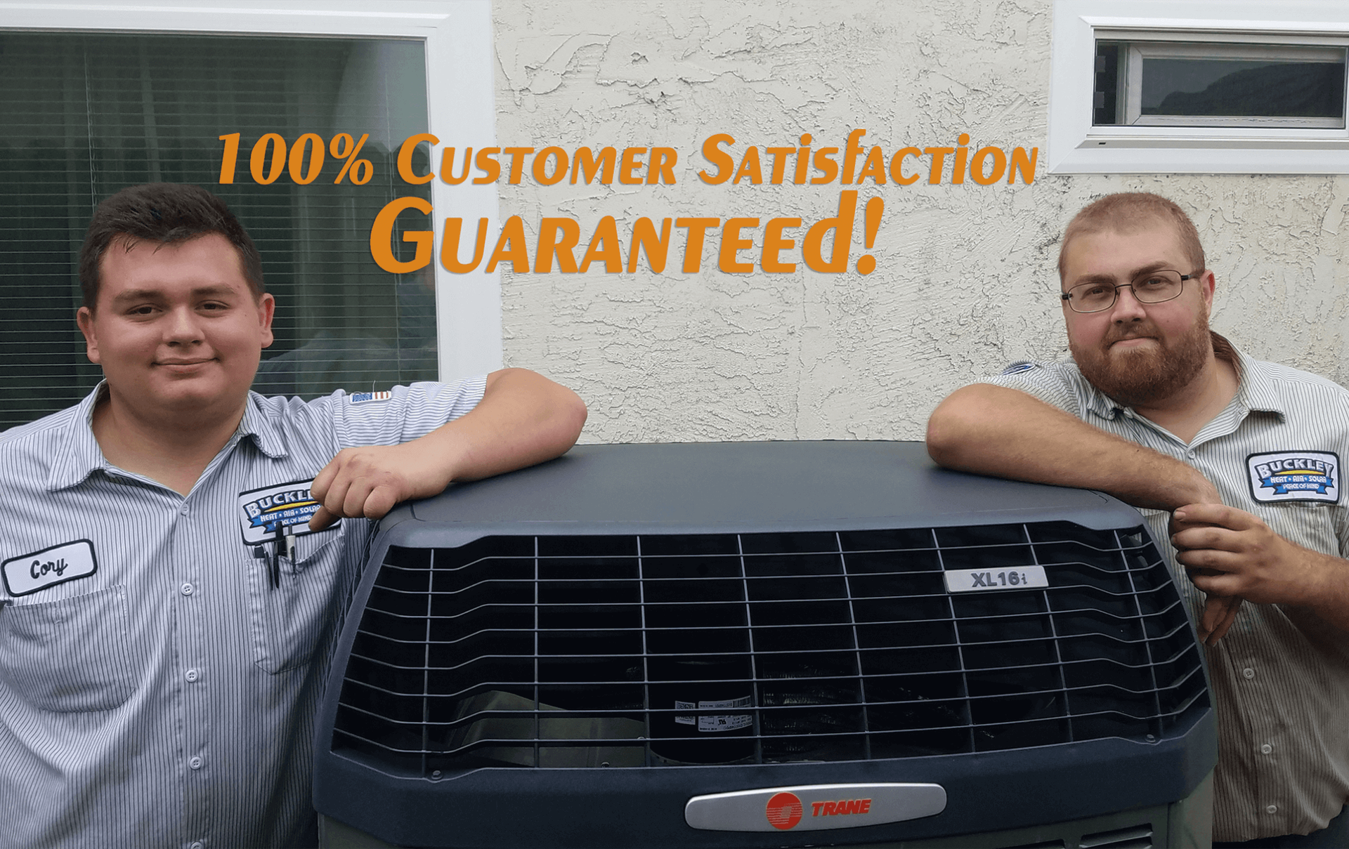two men are standing next to each other holding an air conditioner .
