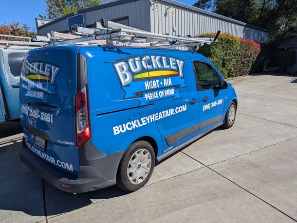 A blue and white buckley truck is parked in a parking lot.