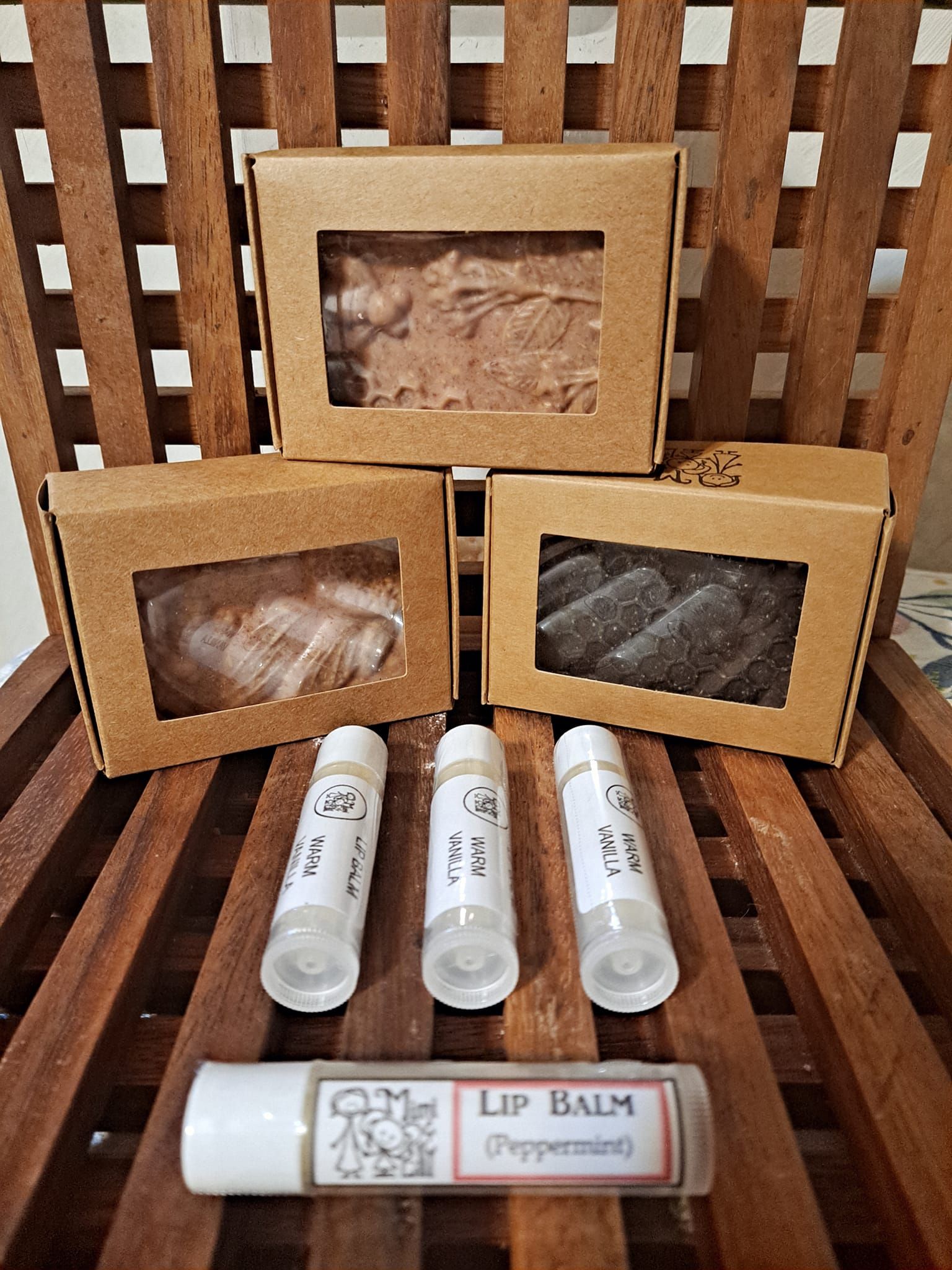A wooden chair with boxes of soap and lip balm on it.