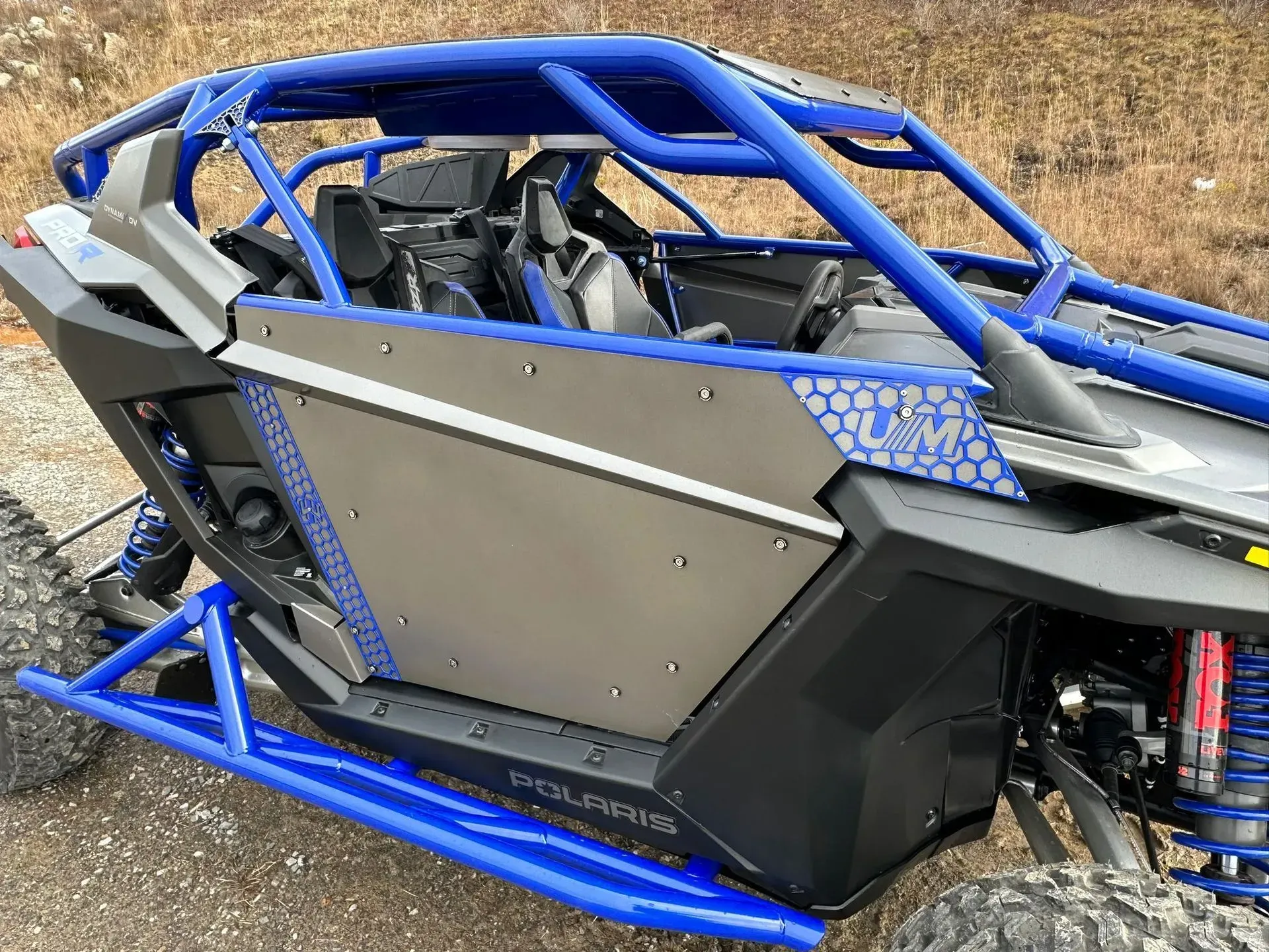 A blue and black atv is parked on the side of the road.