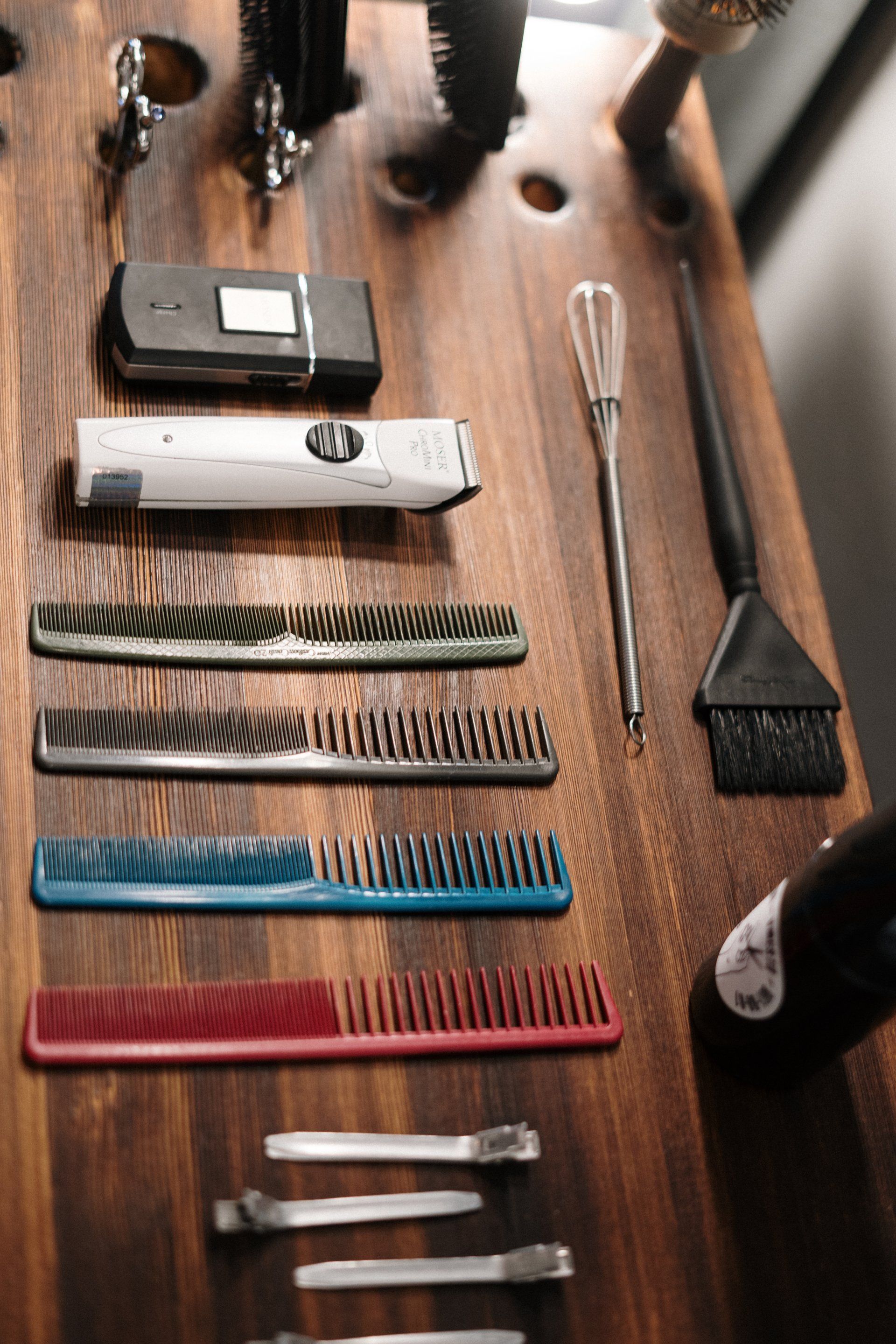 A wooden table topped with combs and brushes.