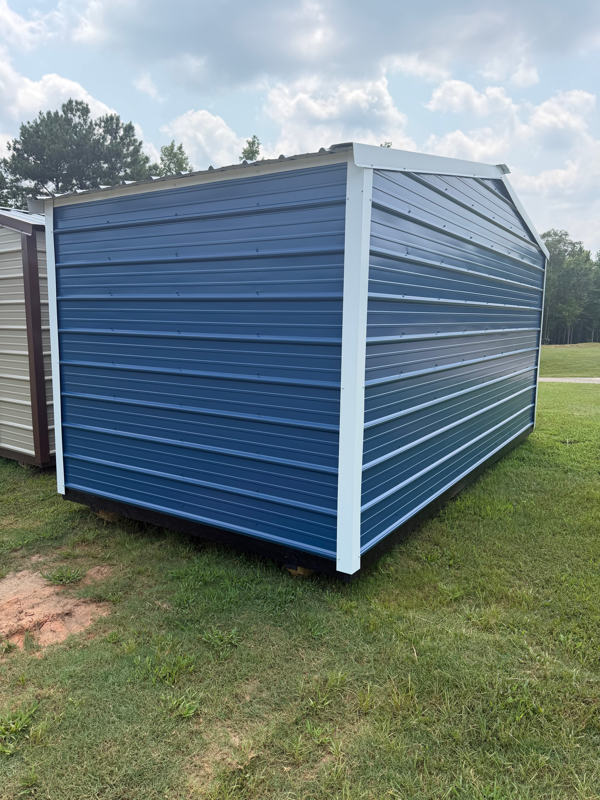 Blue-and-white metal storage shed on a grassy lawn outdoors