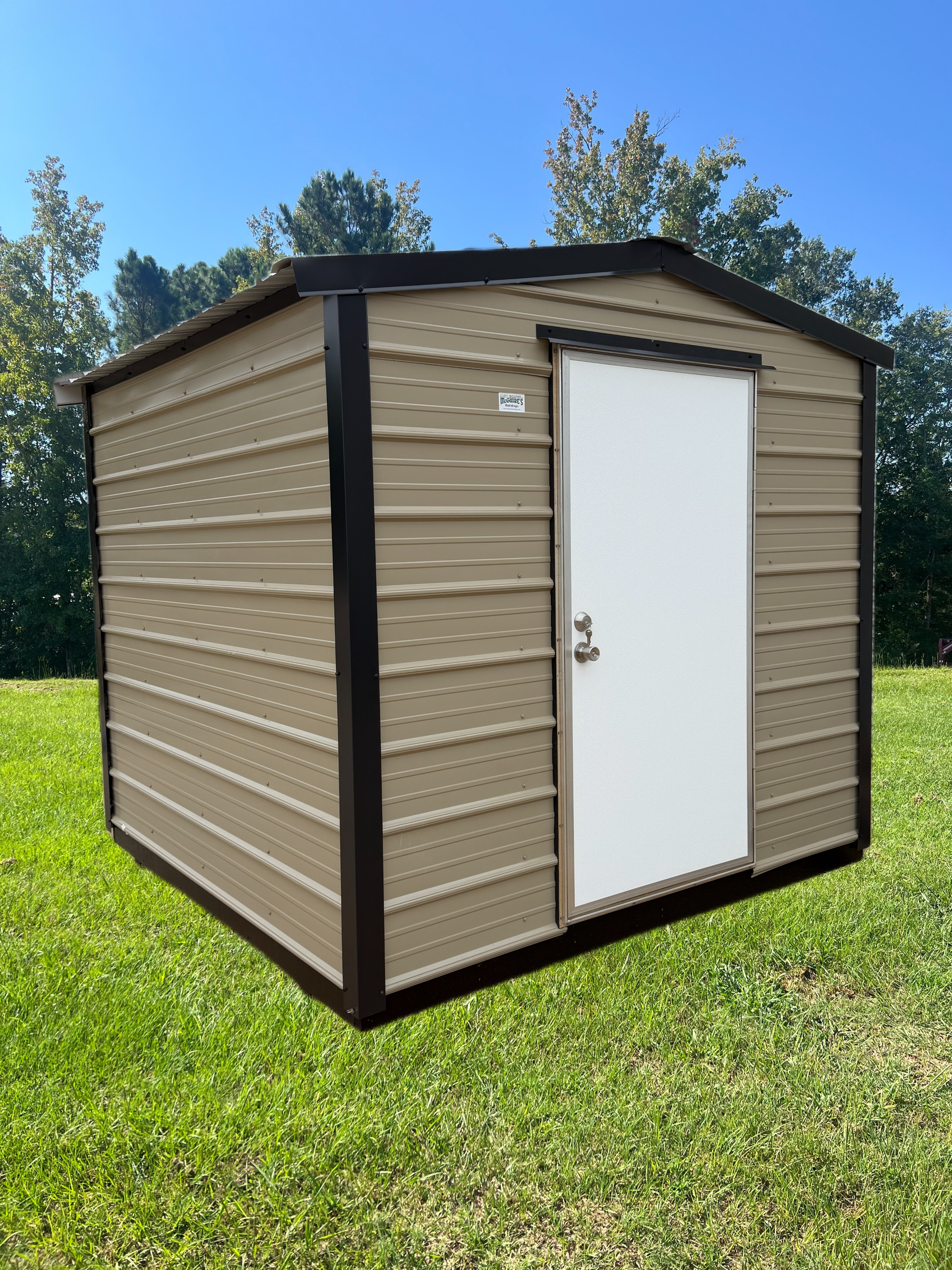 Small tan storage shed with a white door on a grassy lawn under a blue sky