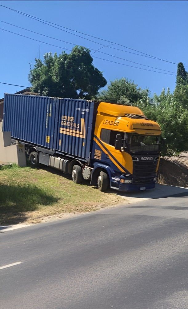 A Blue and Yellow Semi Truck is Driving Down a Road — Leader Removals & Storage in Goulburn, NSW