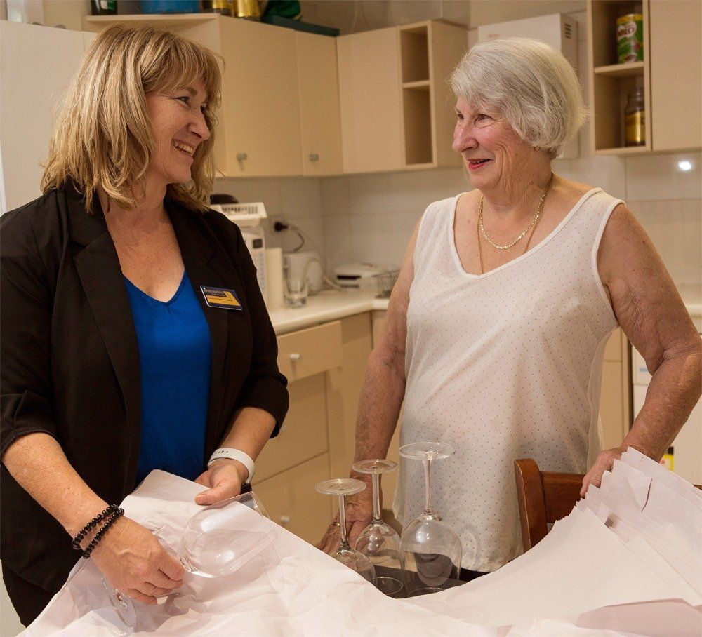 Two Women Are Standing in A Kitchen Talking to Each Other — Leader Removals & Storage in Newcastle, NSW