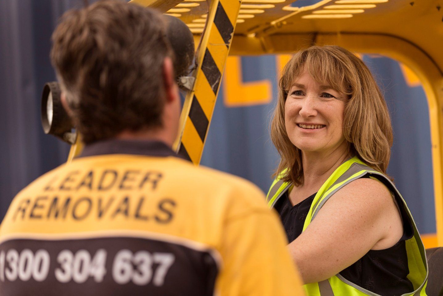 A Woman Wearing a Yellow Vest that Says Leader Removals — Leader Removals & Storage in Canberra, ACT
