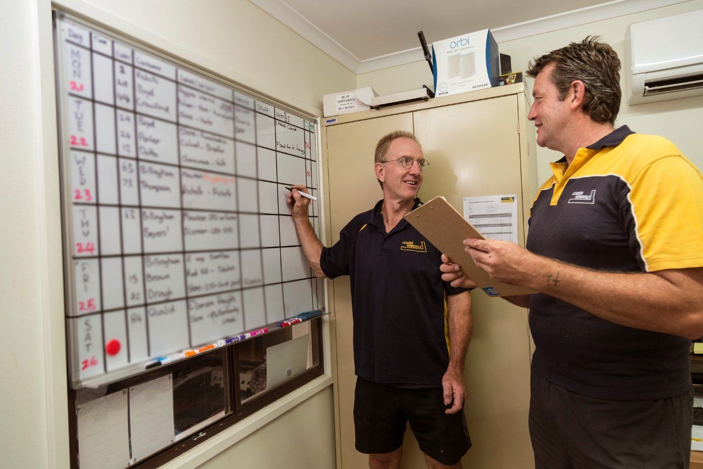 Two Men Are Standing in Front of A White Board — Leader Removals & Storage in Mitchell, ACT