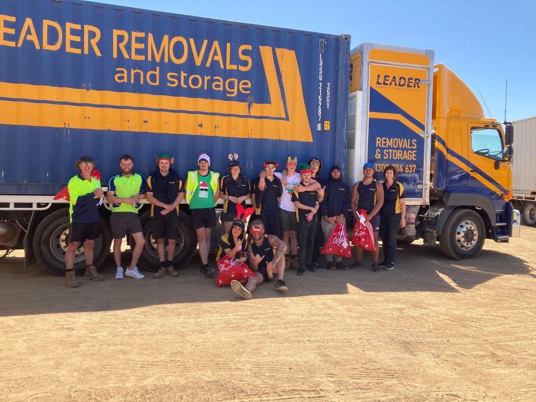 A Group of People Standing in Front of A Leader Removals Truck — Leader Removals & Storage in Wodonga,VIC