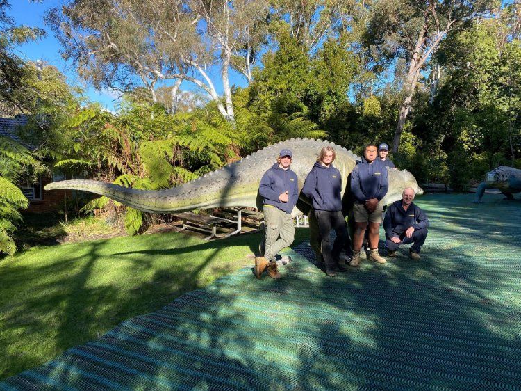 A Group of People Standing in Front of A Dinosaur Statue — Leader Removals & Storage in Canberra, ACT