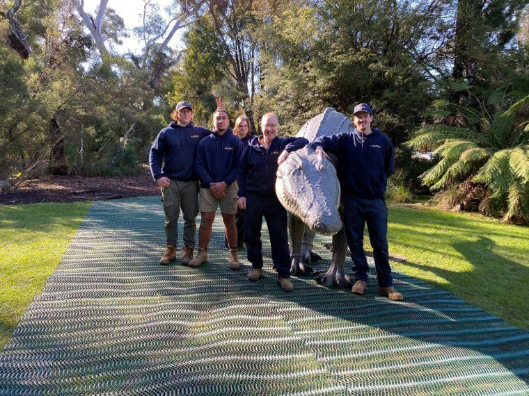 A Group of People Standing Next to A Statue of A Dinosaur — Leader Removals & Storage in Canberra, ACT