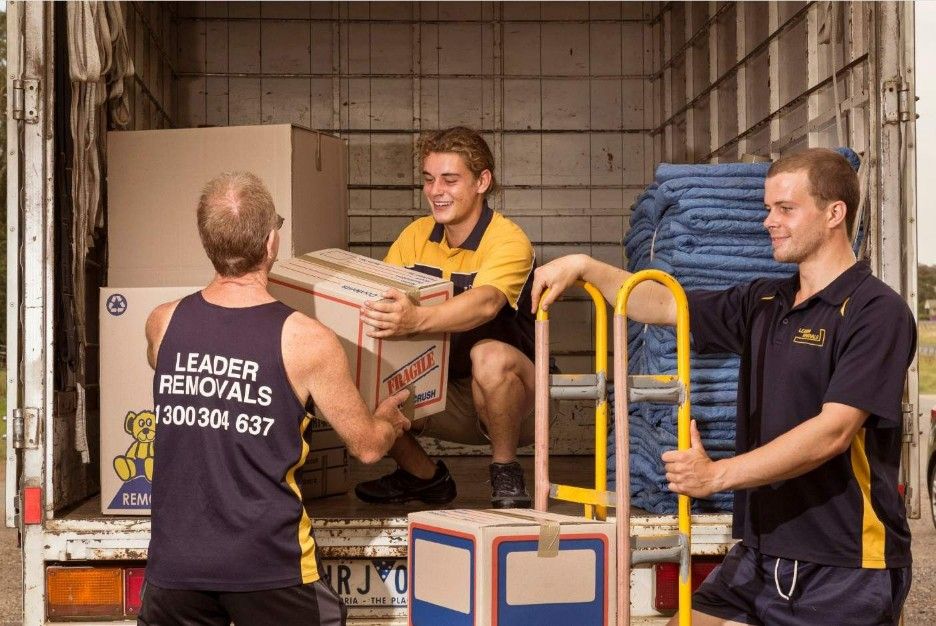 Three Men Moving Boxes In A Van — Leader Removals & Storage in Mitchell, ACT