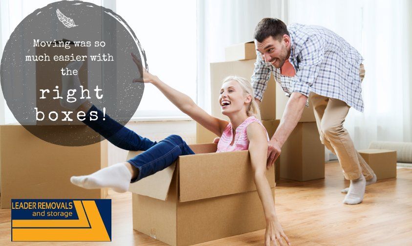 A Man Is Helping a Woman out Of a Cardboard Box — Leader Removals & Storage in Canberra, ACT