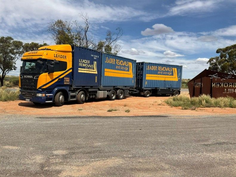 A Blue and Yellow Truck is Parked on the Side of the Road — Leader Removals & Storage in Mitchell, ACT