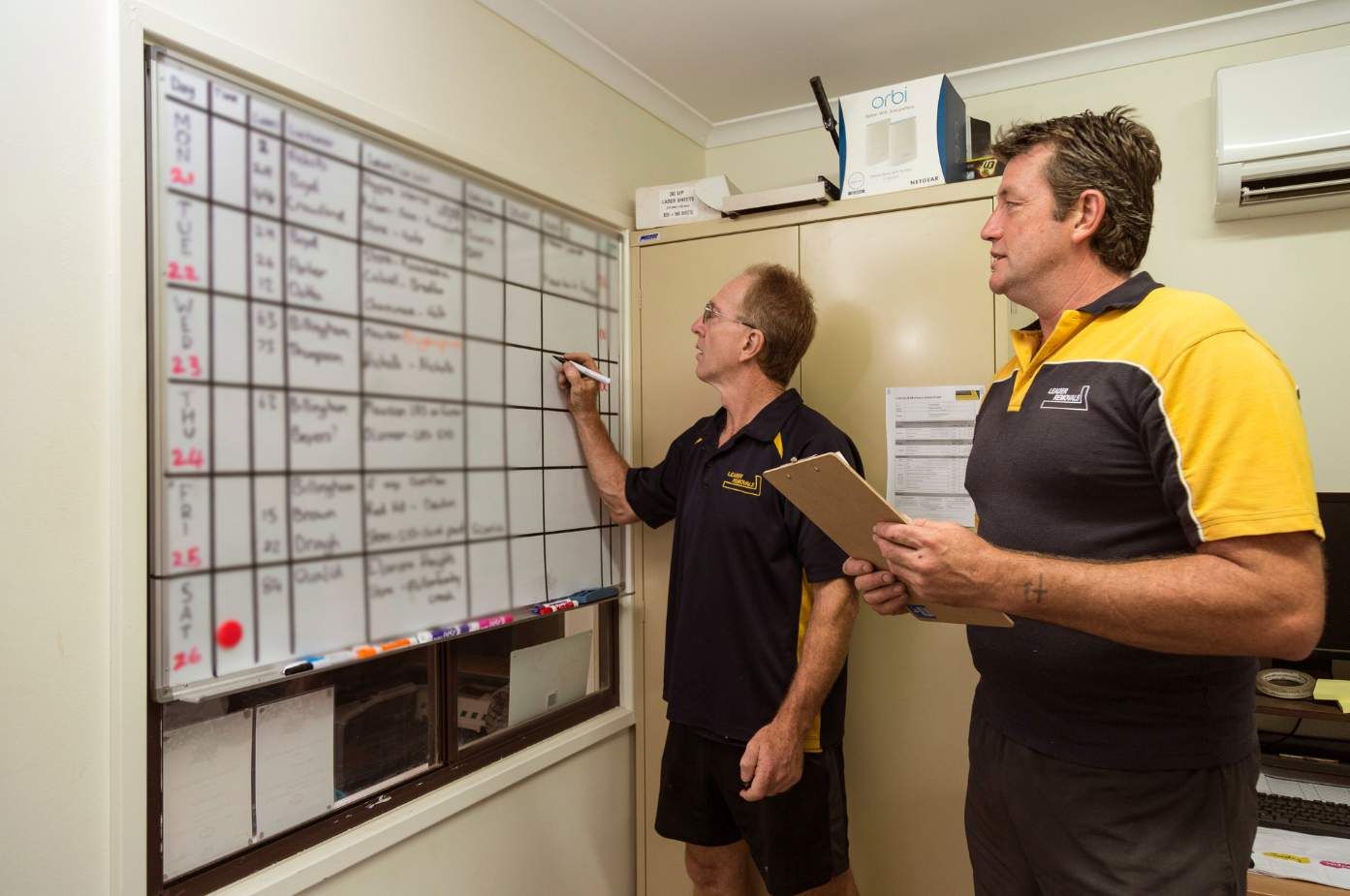 Two Men Are Looking at a Whiteboard in a Room — Leader Removals & Storage in Goulburn, NSW