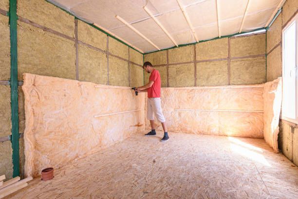 A man is working on a wall in a room.