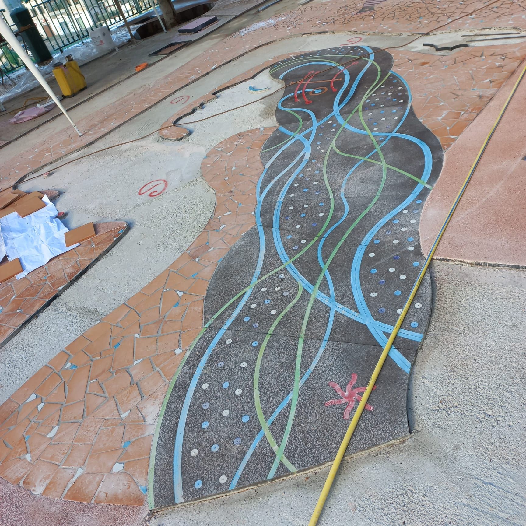 Un disegno di un fiume fatto con il gesso viene misurato con un metro a nastro