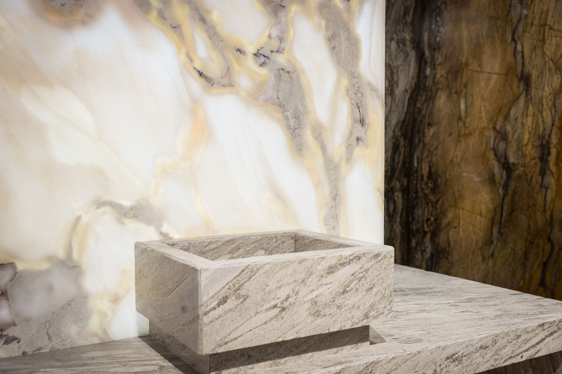 Un bagno con lavandino e parete in marmo.