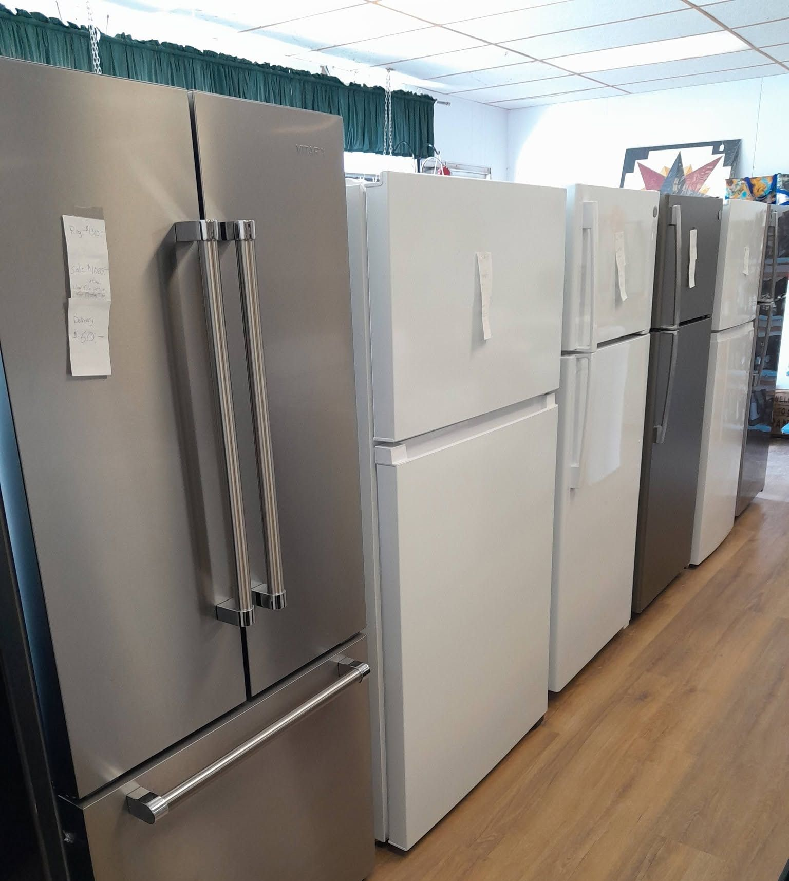 Hand opening a stainless steel refrigerator door to a lit interior