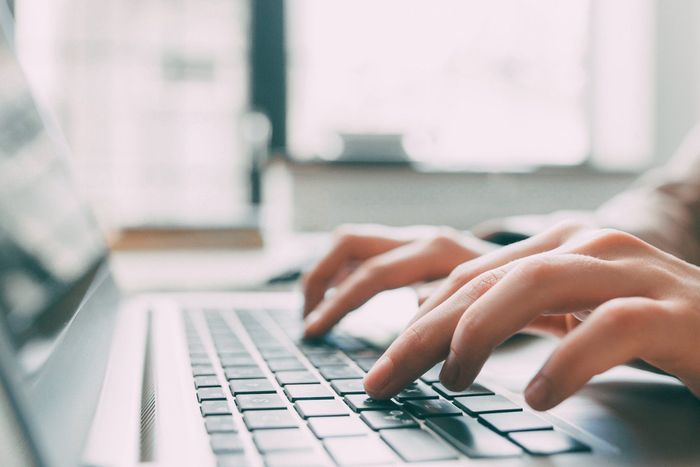 A Person is Typing on a Laptop Computer — Coastal Computing Solutions in Taree, NSW