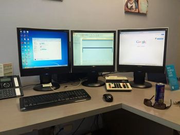 a Desk With Three Computer Monitors and a Keyboard — Coastal Computing Solutions in Taree, NSW