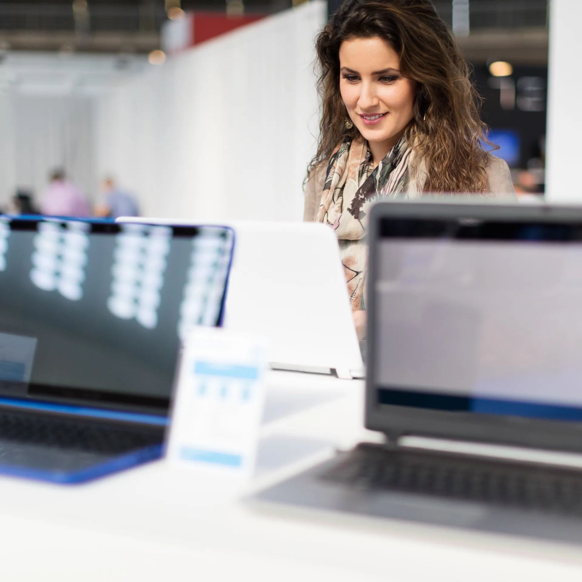 A Woman is Sitting at a Desk Using a Laptop Computer — Coastal Computing Solutions in Taree, NSW