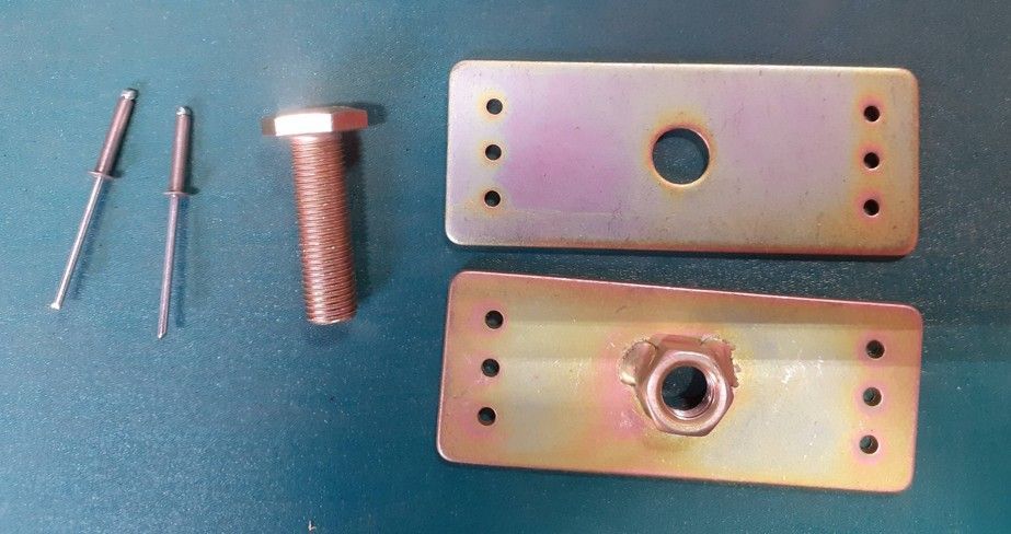 Three metal fasteners and two rectangular metal plates with holes on a blue background
