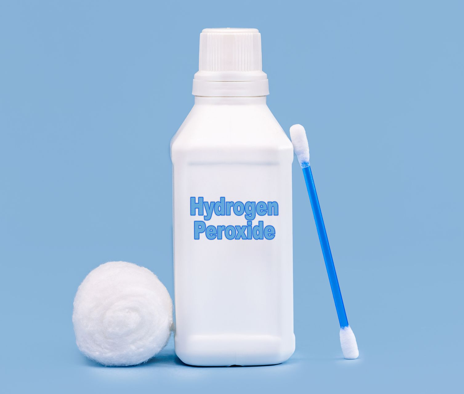 A bottle of hydrogen peroxide with a cotton roll and a blue cotton swab against a light blue background.