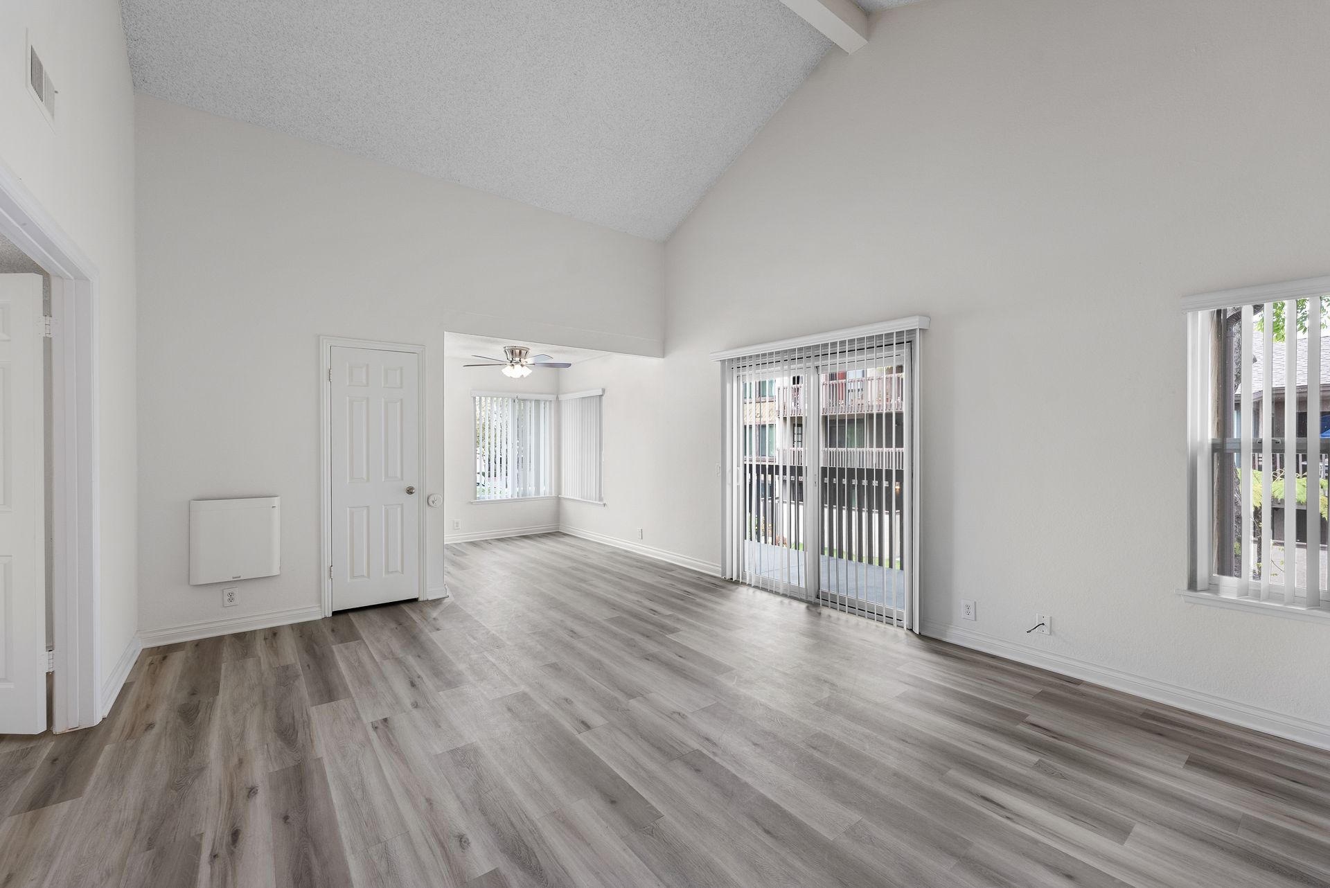 Open living room with sliding glass door and wood floors