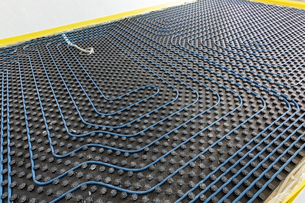 Blue Pipes Snaking Across a Dark — Illawarra Underfloor Heating In Nowra, NSW